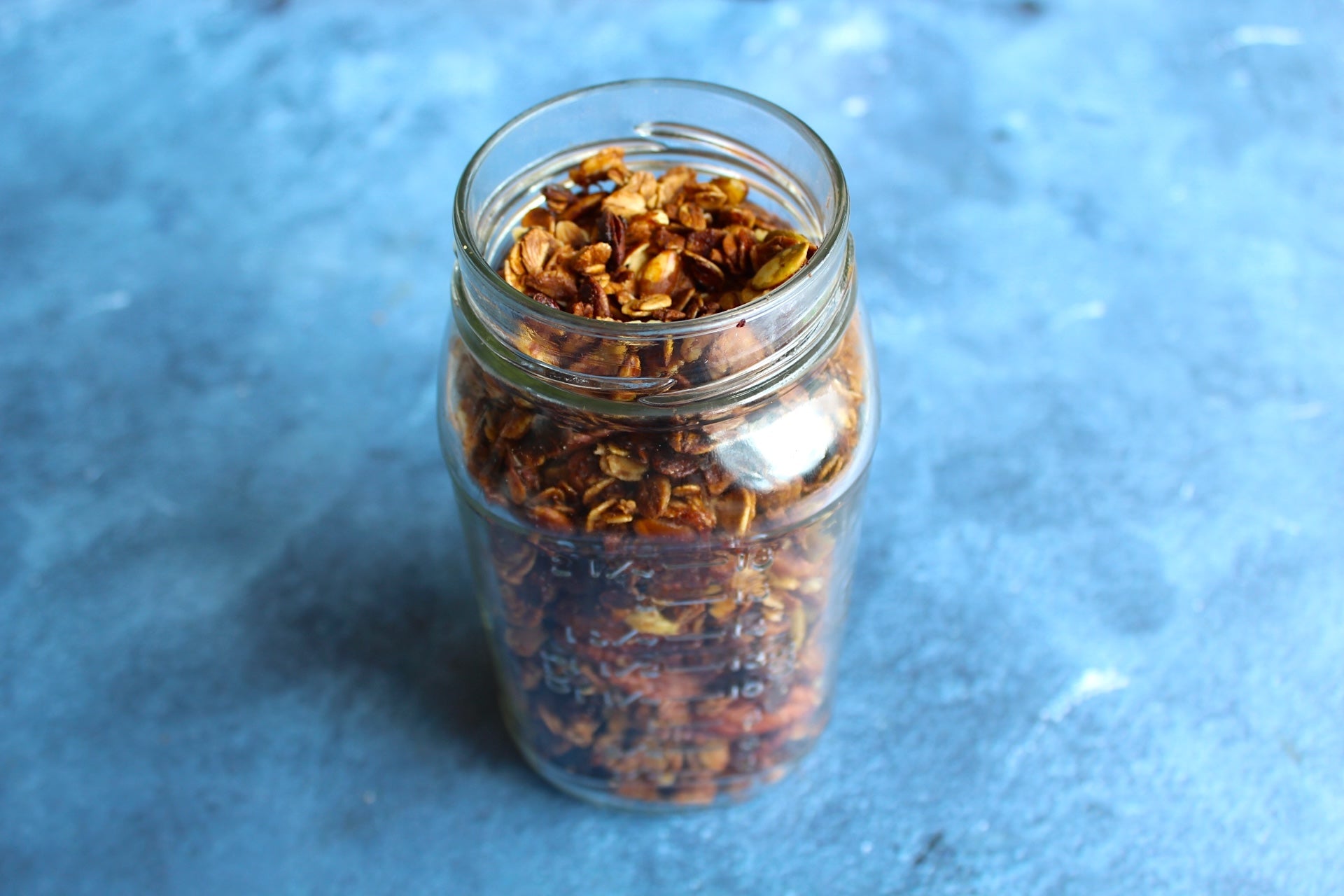 elderberry granola in a jar blue background