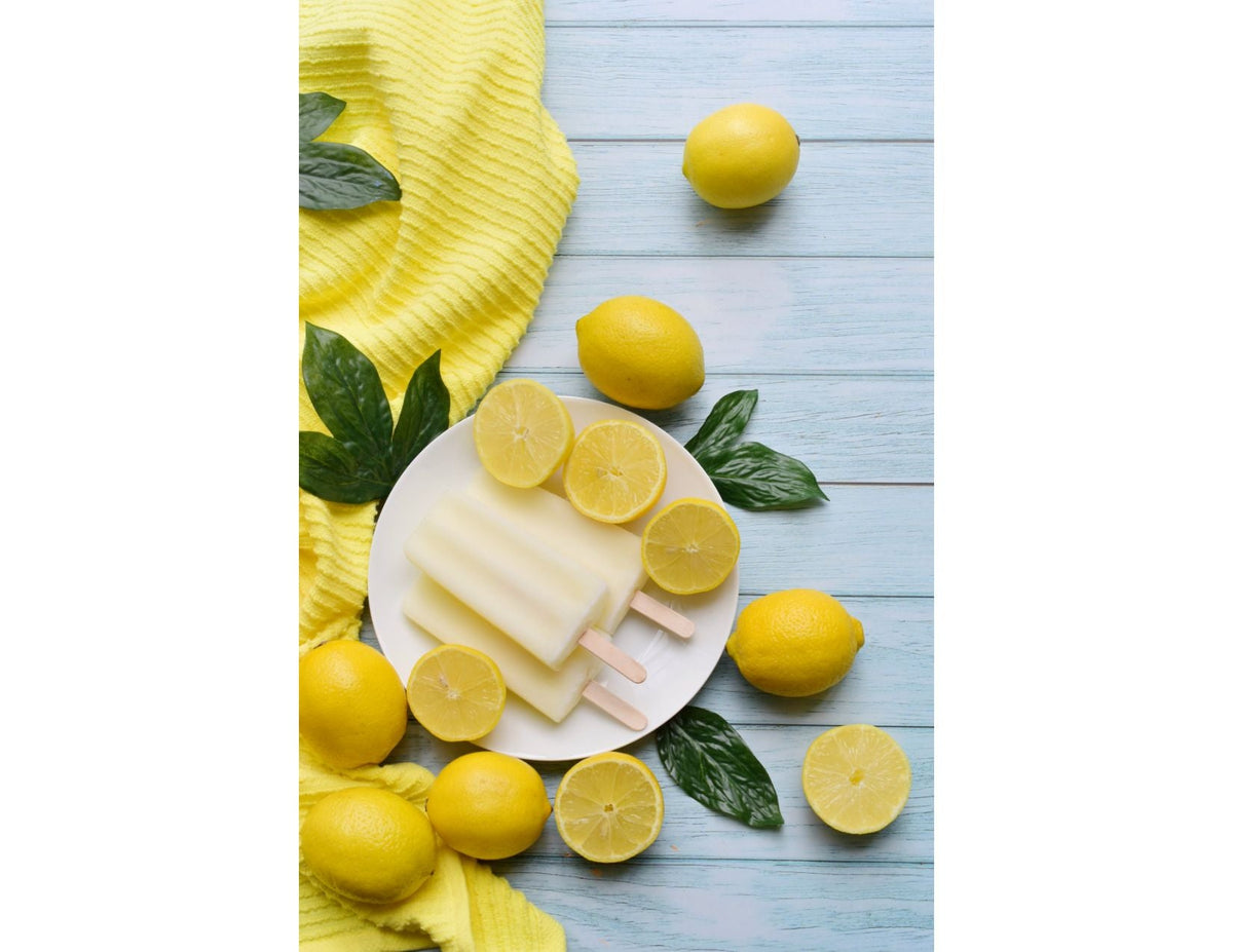 lemon popsicles on a white plate, with lemons around them