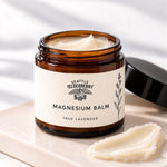 Open Goodnight Magnesium Balm jar showing the balm texture with lavender sprigs (concept render)